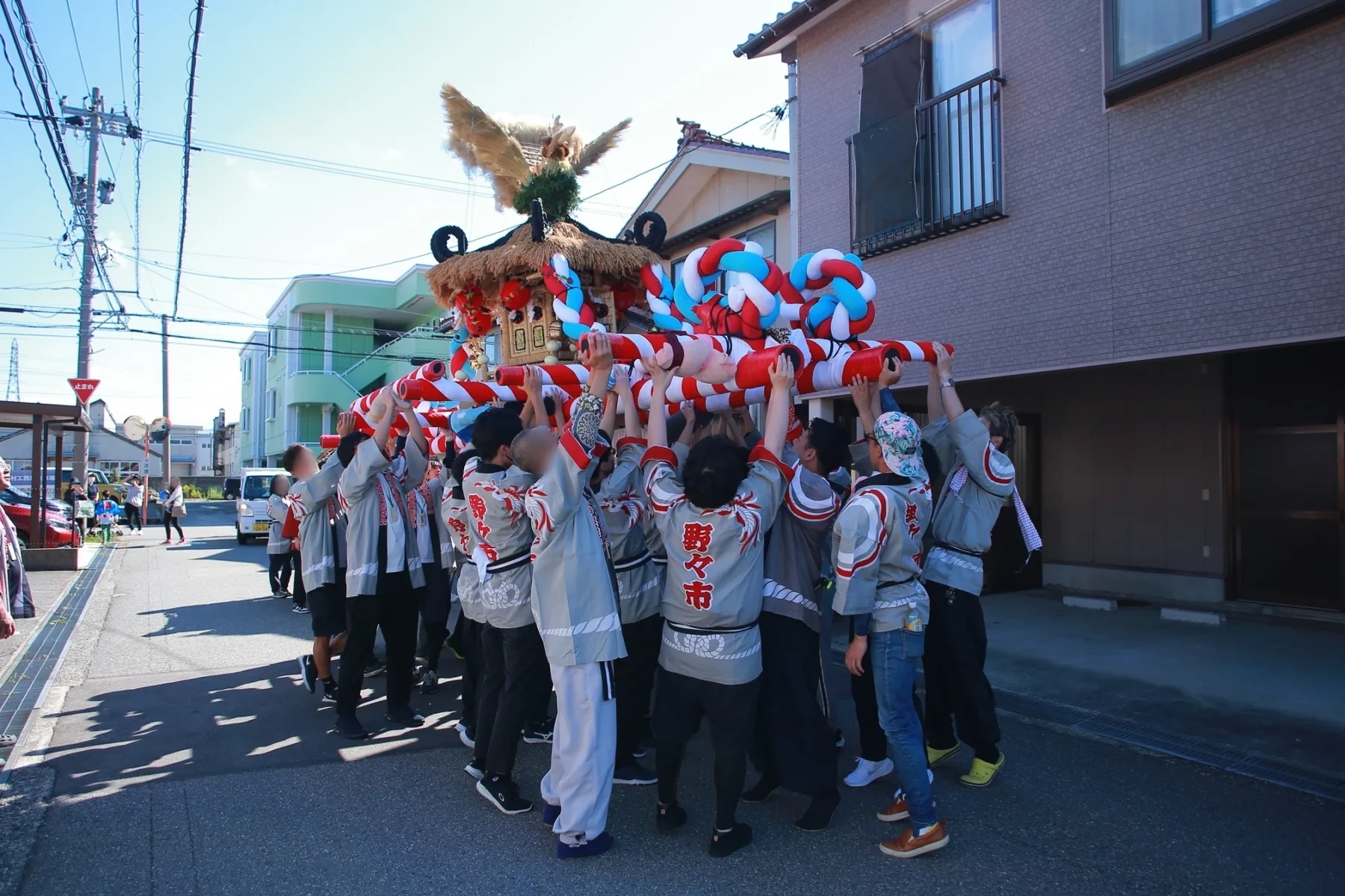 地域の人たちが一緒に豊年野菜神輿を持ち上げる様子