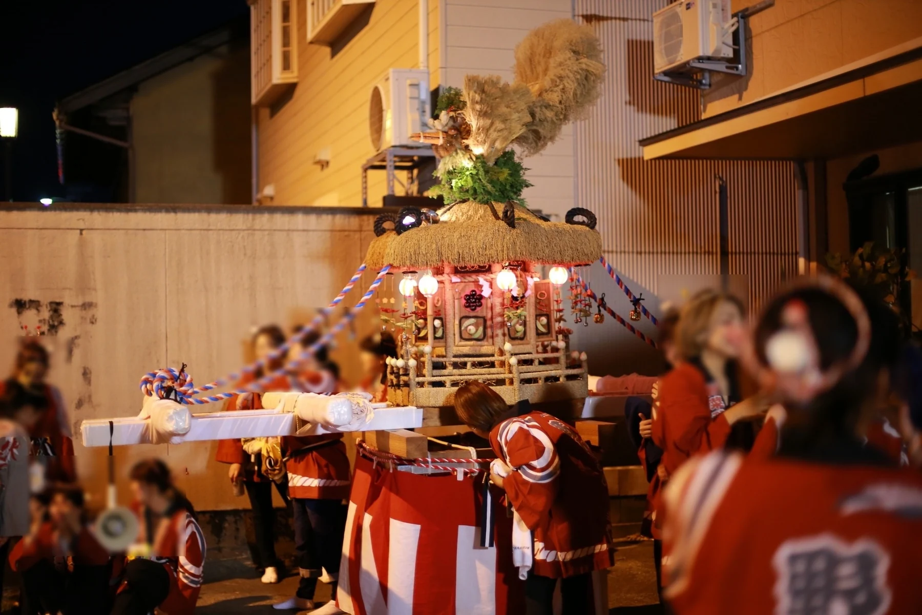 夜間の休憩中に女性神輿を囲む参加者